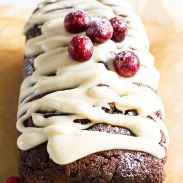 Healthy gingerbread loaf drizzled with icing and topped with cranberries.